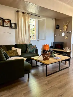 a living room with a couch and a coffee table at La glycine in Saint-Marc-Jaumegarde