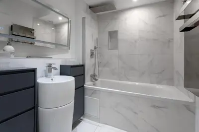 a white bathroom with a tub and a sink at Le Yona Mirabeau - Appartement T3 Atypique situé dans le centre ville historique - proche Rotonde in Aix-en-Provence