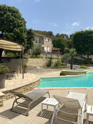 a swimming pool with two chairs and a table and chairs at La Souvenance - Listed villa in the hills in Lagnes