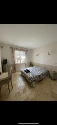 a bedroom with a bed and a chair and a window at Le bon Vivre in Aix-en-Provence