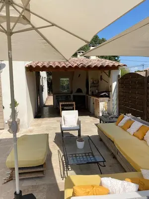 a patio with a couch and an umbrella at Le bon Vivre in Aix-en-Provence