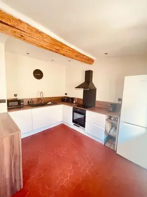 a kitchen with white cabinets and a red floor at Charmant T2bis coeur historique, Clim, possibilité garage in Aix-en-Provence