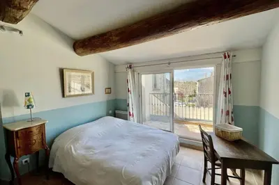 a bedroom with a bed and a table and a window at Village house Stella in Saint-Cannat
