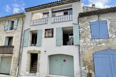 an old building with blue doors and a balcony at Village house Stella in Saint-Cannat