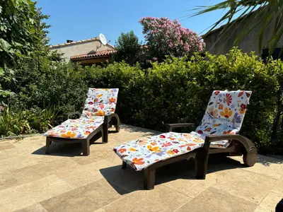 two chairs with floral cushions sitting on a patio at La Cassiopée in Caromb