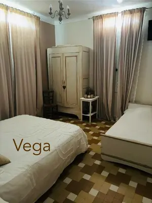 a bedroom with two beds and a dresser in a room at La Cassiopée in Caromb