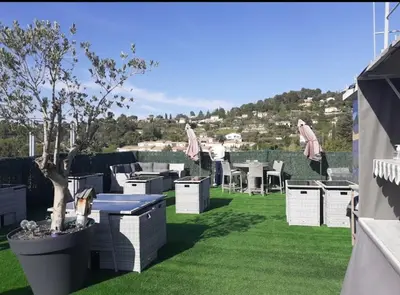 a garden with a table and chairs on the grass at Luberon family in Apt