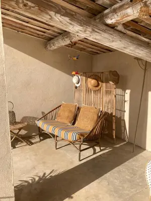 a couch sitting on a porch with a wooden ceiling at Les Lavandes in Saignon
