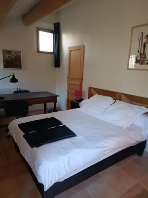 a bedroom with a white bed with a desk and a table at Lou Boulugi in Aix-en-Provence