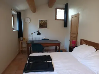 a bedroom with a desk and a bed and a table at Lou Boulugi in Aix-en-Provence