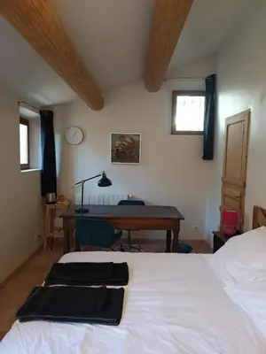 a bedroom with two beds and a desk and a table at Lou Boulugi in Aix-en-Provence