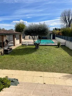 a backyard with a swimming pool and a tree at Dépendance au sein d’une villa avec piscine in Aix-en-Provence