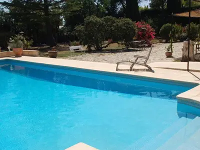 a blue swimming pool with a bench next to it at Camargue Modern retreat in Cavaillon