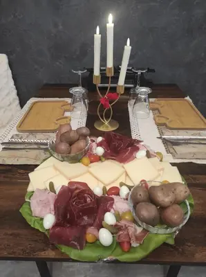 a plate of cheese and vegetables on a table with candles at Gite au nid d'Ange in Lincel
