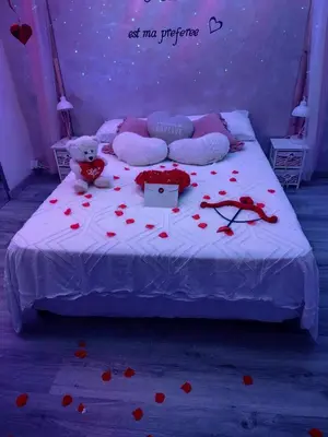 a teddy bear sitting on a bed with hearts on it at Gite au nid d'Ange in Lincel