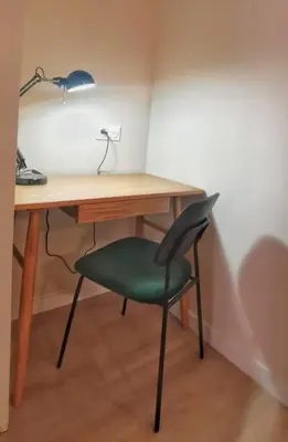 a desk with a green chair and a lamp at Confortable et cosy appartement en centre-ville in Aix-en-Provence