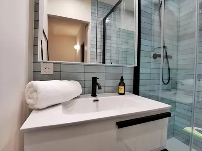 a bathroom with a sink and a shower with a mirror at Confortable et cosy appartement en centre-ville in Aix-en-Provence