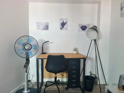a desk with a fan and a chair at Joli studio en plein centre historique in Aix-en-Provence