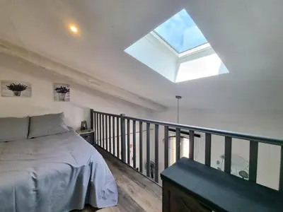 a bedroom with a bed on a balcony with a skylight at Joli studio en plein centre historique in Aix-en-Provence