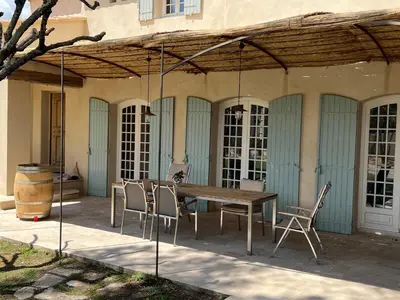 a wooden table and chairs on a patio at LAVENINE a Modène in Modène