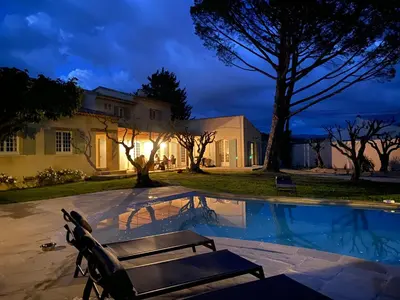 a house with a bench next to a swimming pool at LAVENINE a Modène in Modène