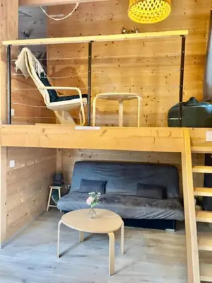 a bunk bed in a room with a table and a chair at Charming Tiny House in LʼIsle-sur-la-Sorgue