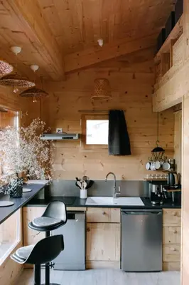 a kitchen with wooden walls and wooden counters at Charming Tiny House in LʼIsle-sur-la-Sorgue