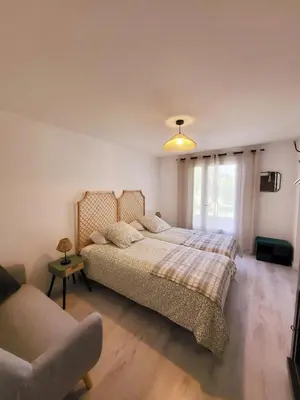 a bedroom with a large bed and a couch at La Villa aux Cyprès bleu in Le Thor