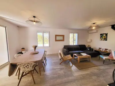 a living room with a table and a couch at La Villa aux Cyprès bleu in Le Thor