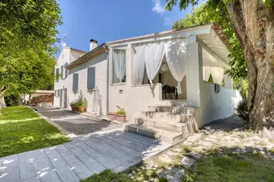 a white house with stairs and a tree at La Villa aux Cyprès bleu in Le Thor
