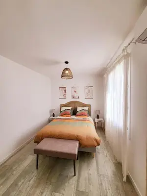 a bedroom with a bed and a large window at La Villa aux Cyprès bleu in Le Thor