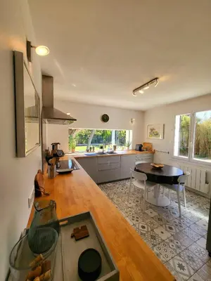 a kitchen with a table and a dining room at La Villa aux Cyprès bleu in Le Thor