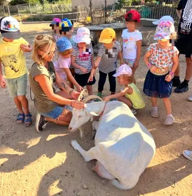 a woman petting a cow in front of a group of children at Séjour à la ferme in Jouques
