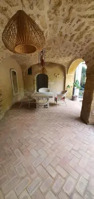a room with a stone wall with a table and chairs at Clos des Jasmins avec sa jolie cour intérieure in Lourmarin