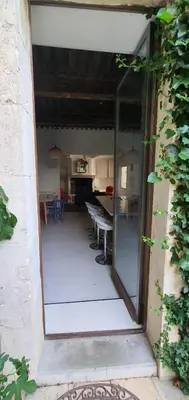 an open door to a kitchen and a dining room at Clos des Jasmins avec sa jolie cour intérieure in Lourmarin