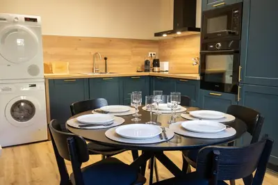 a kitchen with a table and chairs and a kitchen with a sink at Le Triplex - 8 pers - Hypercentre - Wifi in LʼIsle-sur-la-Sorgue