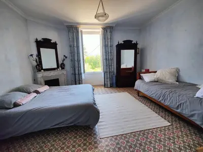 a bedroom with two beds and a fireplace and a window at Chambre 3 personnes avec salle de bain dans mas du Lubéron in Robion en Luberon