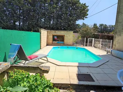 a swimming pool with a chair and a chair sidx sidx sidx at Chambre 3 personnes avec salle de bain dans mas du Lubéron in Robion en Luberon