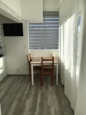 a dining room with a table and chairs and a television at La maison Anaïa in Gargas