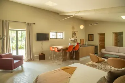 a living room with a kitchen and a table and chairs at Proche l'Isle/Sorgue, loft avec SPA et Piscine in Le Thor