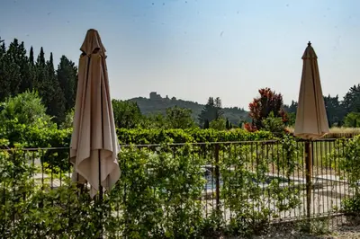 two brown umbrellas sitting next to a pool at Proche l'Isle/Sorgue, loft avec SPA et Piscine in Le Thor