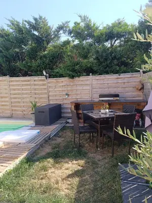 a patio with a table and chairs and a fence at La Cigale sous l'Olivier - Chambre , SdB et Salon Privé - Piscine in Les Taillades