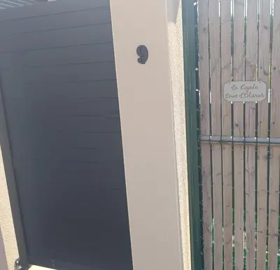 a gate with a sign that reads be grand over gunfire at La Cigale sous l'Olivier - Chambre , SdB et Salon Privé - Piscine in Les Taillades