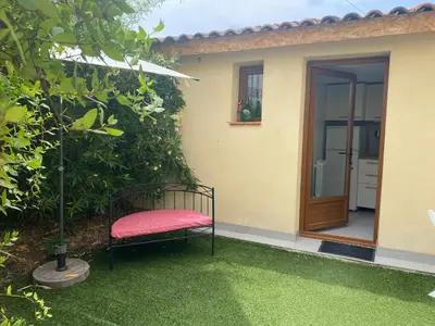a chair sitting on the grass in front of a house at A 20 minutes de Aix en Provence in Pertuis