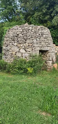 an old stone wall in a field of grass at CHRIS LE VERGER in Saignon