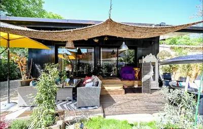 a house with a patio with chairs and umbrellas at Nouveau ENVOUTEMENT près de GORDES Provence Maison entière neuve archi luxe écolo 4 pers parking privé in Robion en Luberon