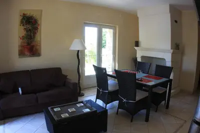 a living room with a couch and a table and chairs at Les Pres de Gordes in Gordes