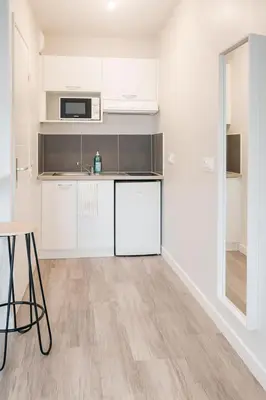a kitchen with white cabinets and a table at 014 Studio Provençal - Proche d'Aix en Provence in Éguilles
