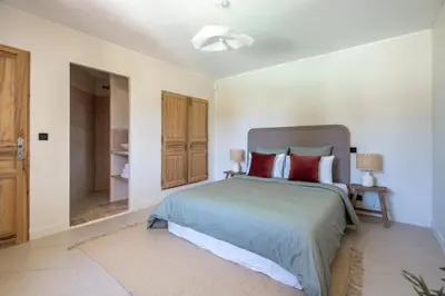 a bedroom with a large bed with red pillows at La Bastide Des As in Gordes