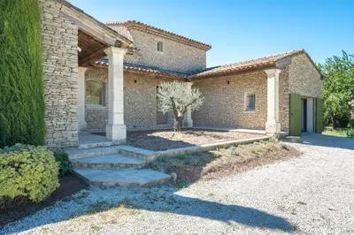 a brick house with a pathway in front of it at La Bastide Des As in Gordes